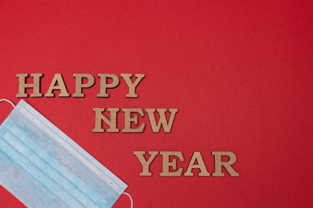 医用防护口罩，红色背景。题词新年快乐。圣诞和新年贺卡，横幅，广告概念。俯视图照片，极简主义，复制空间。医疗断然。图片下载
