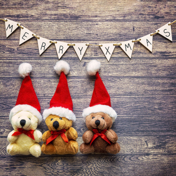 圣诞节或新年的装饰背景与圣诞熊在不同的颜色下吊索与圣诞快乐的木头桌子与拷贝空间。图片下载