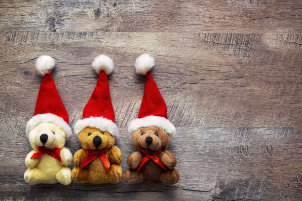 圣诞节或新年装饰背景用不同颜色的圣诞熊放在有拷贝空间的木桌上。图片下载