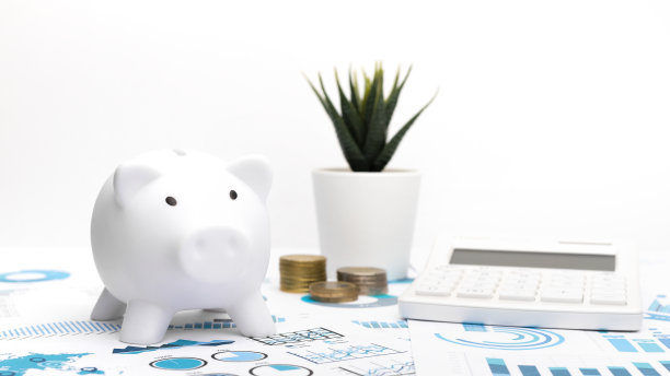 以文件为背景，用存钱罐、计算器和硬币分析财务报告。图片下载