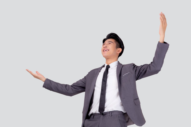 肖像商人的西装站在赢得成功孤立在白色的背景，年轻的亚洲商人是经理或主管有自信和兴奋的积极的表达和情感。图片下载