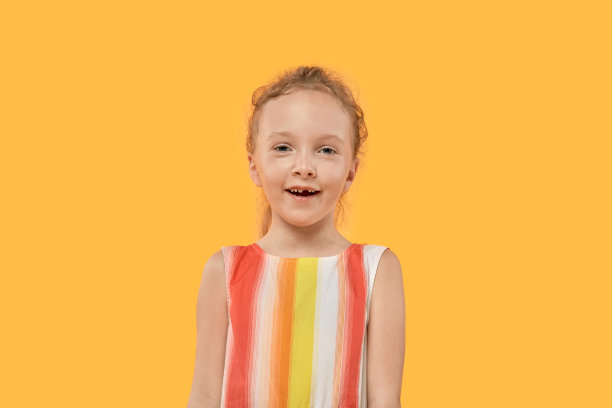 有趣的没有牙齿的金发女孩。明亮的彩色礼服。图片下载