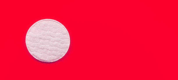 白色棉质卫生巾在红色板上，特写细节从上面，文字右边的空间图片下载