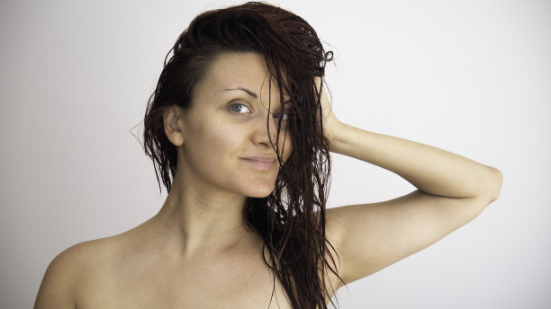 一个白人妇女的肖像与湿头发在一个白色的背景。图片下载