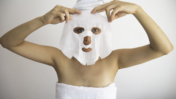 妇女戴上或摘下白色化妆面膜。图片下载
