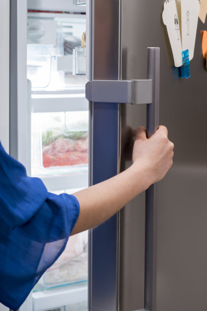 女人用手打开冰箱门图片下载