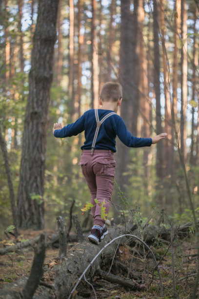 带着背带的男孩，在树林里玩耍。复古风格和军事主题的概念。图片下载