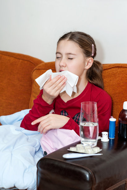 生病的小女孩躺在床上用手帕擤鼻子图片下载