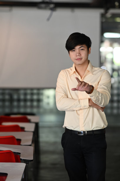 一个商人站在会议室，手指对着摄像机的肖像。图片下载