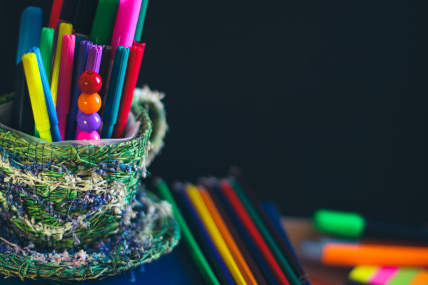 在学校黑色黑板的背景上涂上铅笔和钢笔。在黑板上放一个拷贝空间。图片下载