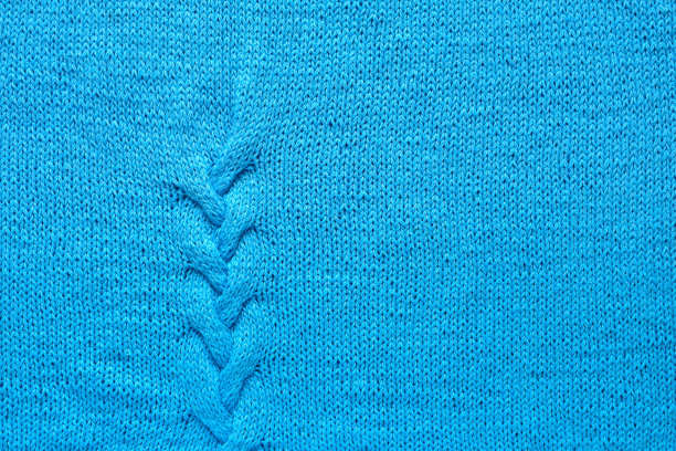 蓝色纱线的针织物。手工编织图案âbraidâ。背景纹理。图片下载