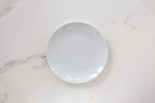 空白陶瓷板孤立在白色大理石背景。副本的空间。菜单菜谱的概念图片下载