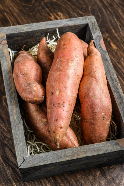 木桌上的红薯。木制背景。俯视图图片下载