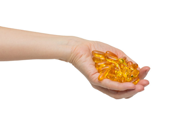 女人的手拿着一堆欧米伽-3胶囊图片下载