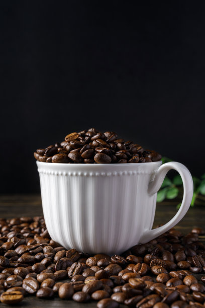 木质背景上的咖啡豆和杯子图片下载