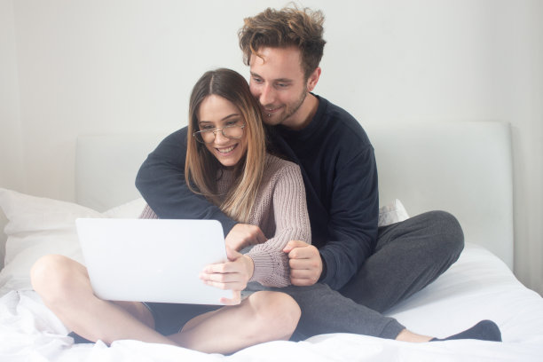 一对夫妇在他们的卧室里舒适地上网图片下载