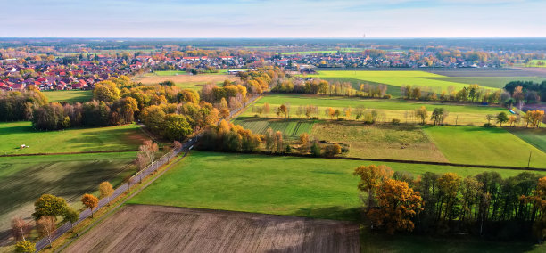鸟瞰图的平坦风景在德国北部，一个村庄在背景上对着笔直的地平线图片下载