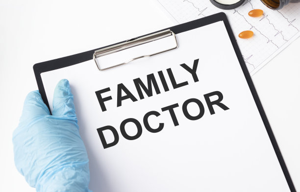 一位戴口罩、穿着医疗服的医生展示了一张写有“家庭医生”字样的卡片。医学概念。图片下载