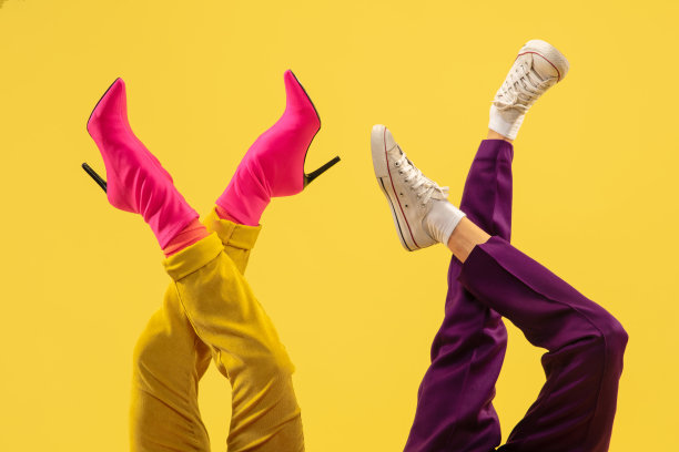 时尚模特的脚在明亮时尚的鞋孤立在黄色背景。图片下载