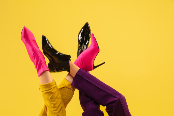 时尚模特的脚在明亮时尚的鞋孤立在黄色背景。图片下载