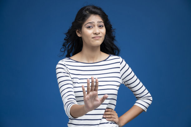 年轻女子在蓝色背景-股票照片图片下载