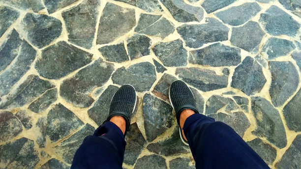 男人的脚俯视图男人在简单的凉鞋站在石头地板陶瓷照片模板与复制空间图片下载