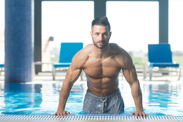 年轻的男子在酒店室内游泳池图片下载