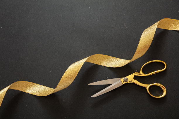 隆重开幕。金剪刀剪金缎带，黑色背景图片下载
