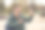 自信迷人的年轻人穿着绿色风衣书包在城市街道外传递现代设备的照片图片下载