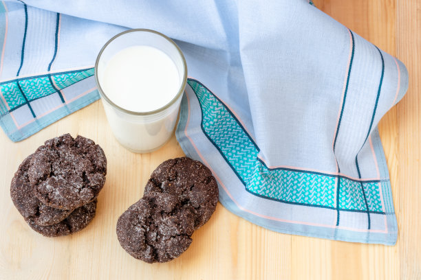 平躺的照片，早餐，新鲜牛奶和巧克力饼干，在木桌子上和蓝色的毛巾。图片下载