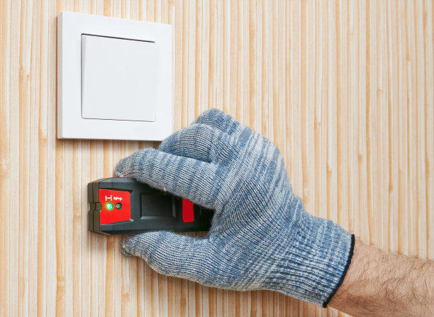 电工用电缆探测器扫描墙壁，寻找隐藏的电线，在房子里工作，近距离，浅深度的锐度图片下载