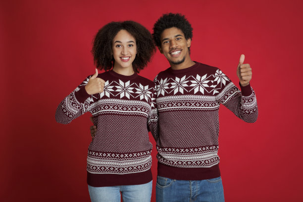 圣诞快乐，恭贺新禧。一对年轻的非洲裔美国夫妇竖起大拇指图片下载