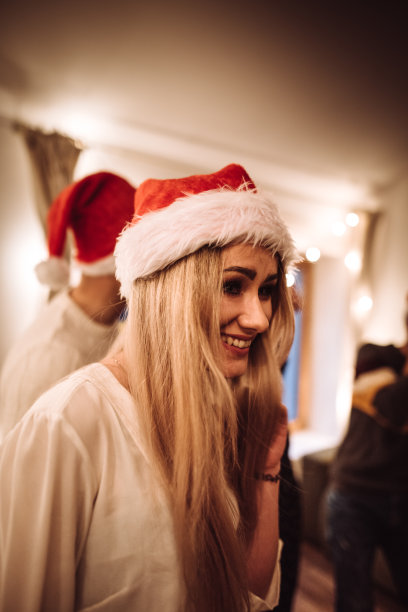 人们戴着圣诞老人的帽子在家跳舞图片下载