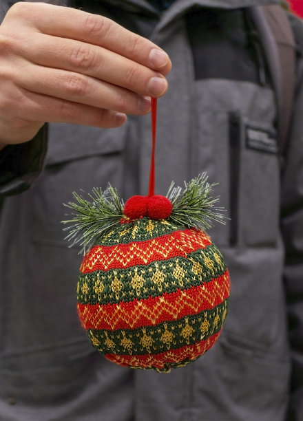 红绿色针织圣诞球在手特写。圣诞和新年礼物，背景图片下载