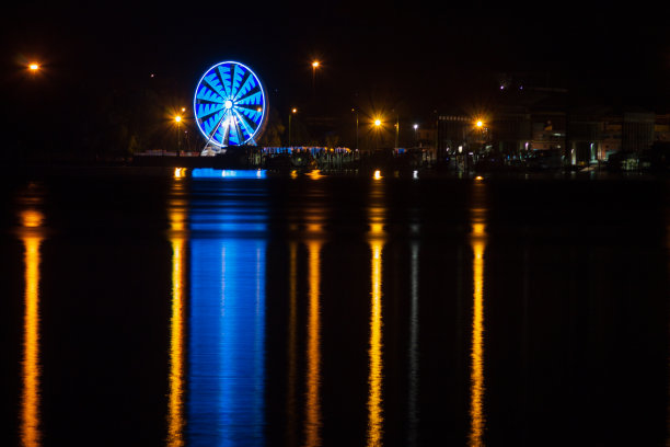 夜晚灯光倒映在湖面上，欣赏阿罗纳的摩天大楼。意大利。图片下载