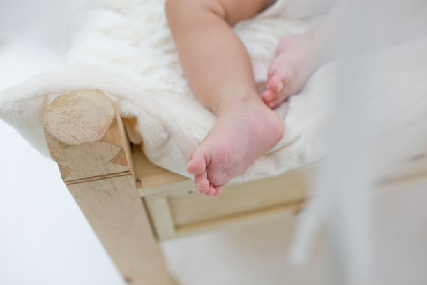 新生婴儿的脚在白色的皮毛上图片下载