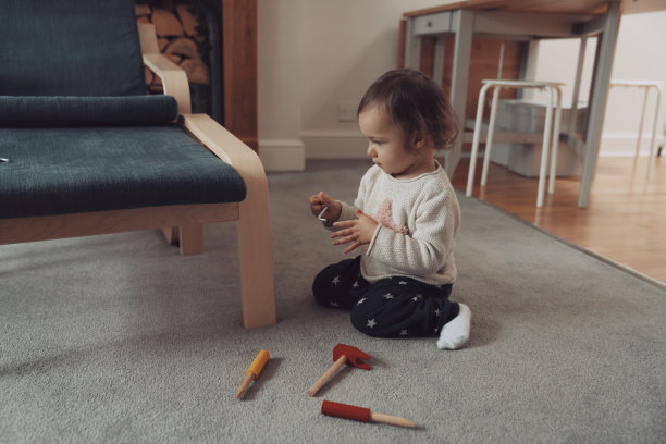 小女孩用她的玩具螺丝刀紧固家具图片下载