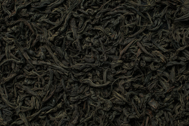 黑色大叶茶作为背景。干红茶叶子的质地。黑色背景图片下载