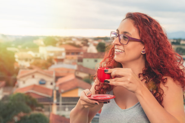 红发女孩戴着眼镜在她的公寓里喝咖啡图片下载