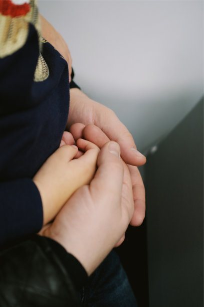 父亲的手掌拥抱着孩子的手掌。育儿及关怀理念图片下载