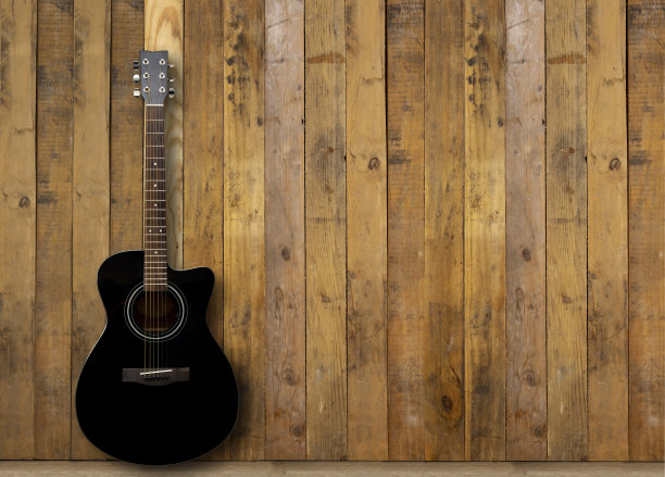 木地板上放着一把黑色的原声吉他图片下载