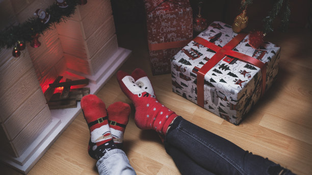 圣诞节前夕在壁炉前的两个人的腿的特写照片图片下载