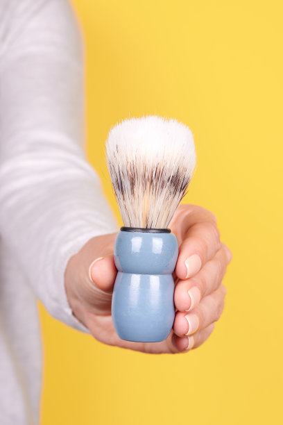 用木质剃须刷在黄色背景上。图片下载