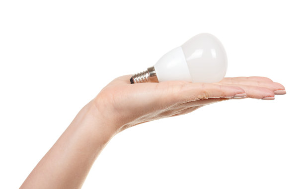 手与白色LED灯泡隔离在白色背景。图片下载