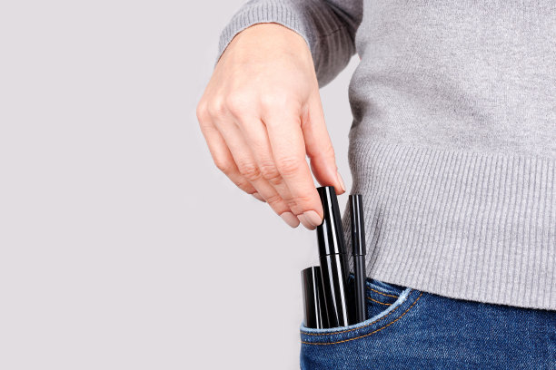 在灰色背景下，将化妆物品放在牛仔裤口袋里。图片下载