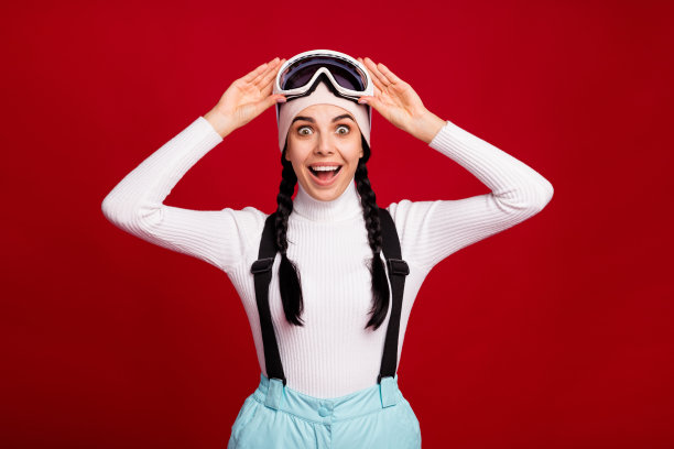 年轻美丽的照片震惊，惊讶，快乐积极的女孩滑雪看到大销售孤立在红色背景图片下载