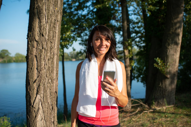 美丽的女人锻炼跑步和户外健身与移动智能手机和运动健康应用程序图片下载