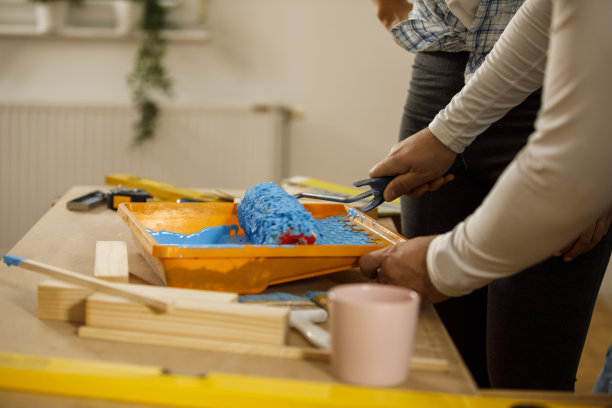 将油漆辊浸在蓝色油漆中图片下载