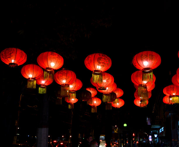 春节晚上的红灯笼，映衬着五彩缤纷的散景。晚上用灯光作背景装饰。图片下载