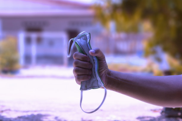 手持医用口罩的男子标志着隔离隔离的结束和正常生活的开始。结束冠状病毒大流行。图片下载